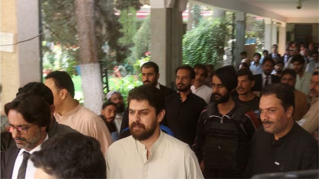 Policemen escort tribal chief Sher Baz Satakzai, accused of ordering deaths of a couple accused of having an affair,