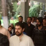 Policemen escort tribal chief Sher Baz Satakzai, accused of ordering deaths of a couple accused of having an affair,