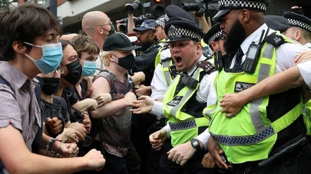 Migrant hotel protests rock the rich postcodes of London: ‘Asylum seekers’ film and laugh at clashes.